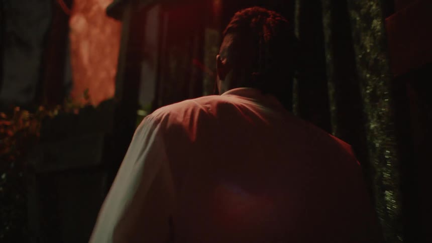 A man enters a nightclub in a city at night
