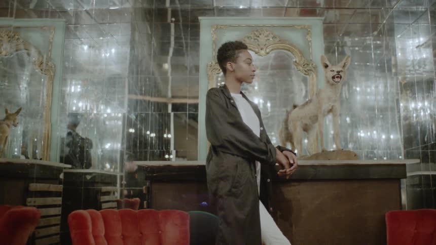 A woman stands next to a taxidermy feline