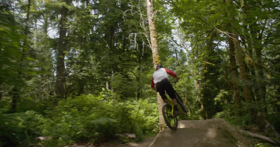 A man jumps over a hill on his bicycle