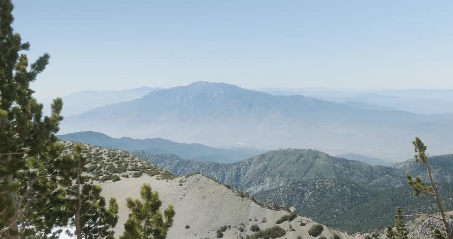 Tree covered rocky mountains partially covered by fog