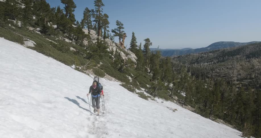 Hikers trek through the snow on the side of the mountain