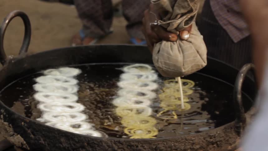 Person pours while liquid into a fryer out of a small bag