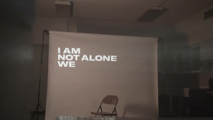 Words flash on a projector screen in an empty room