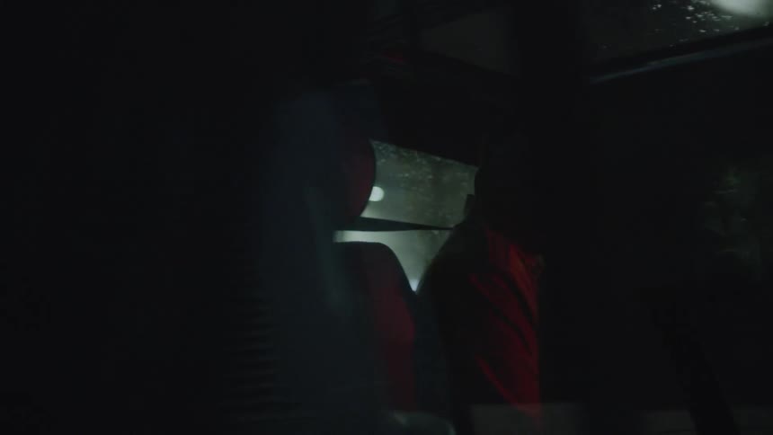 The driver looks back and talks to someone in the back seat