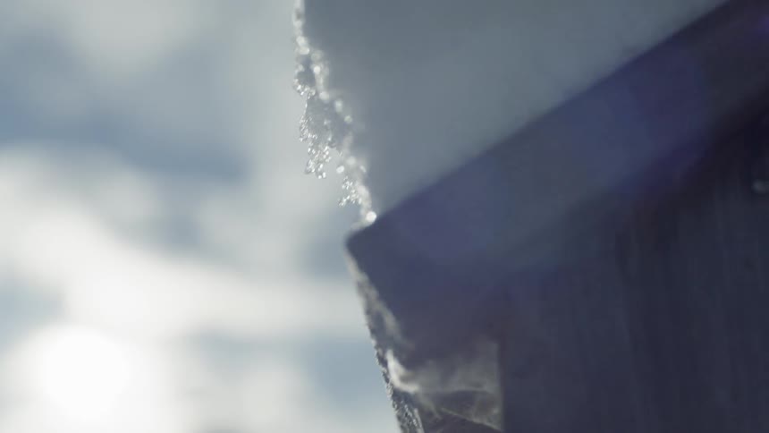 Snow sits on a roof on a sunny day