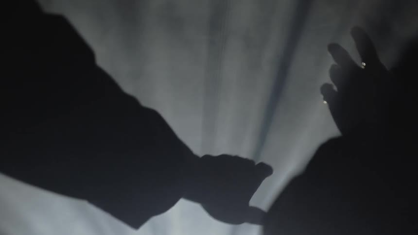 Hands are held into projected lights