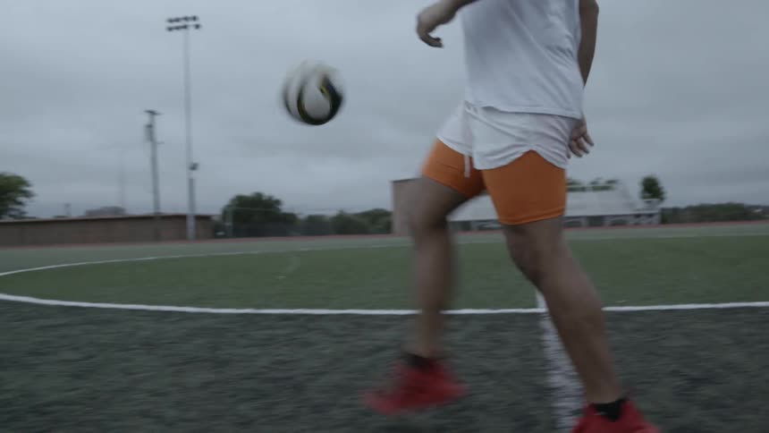 A soccer player dribbles the ball on the field