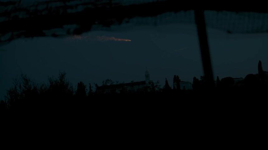 Dark night with a single firework flying in the sky