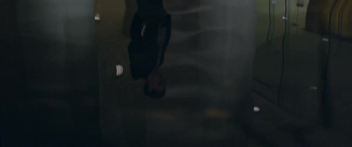 A man stands above a puddle