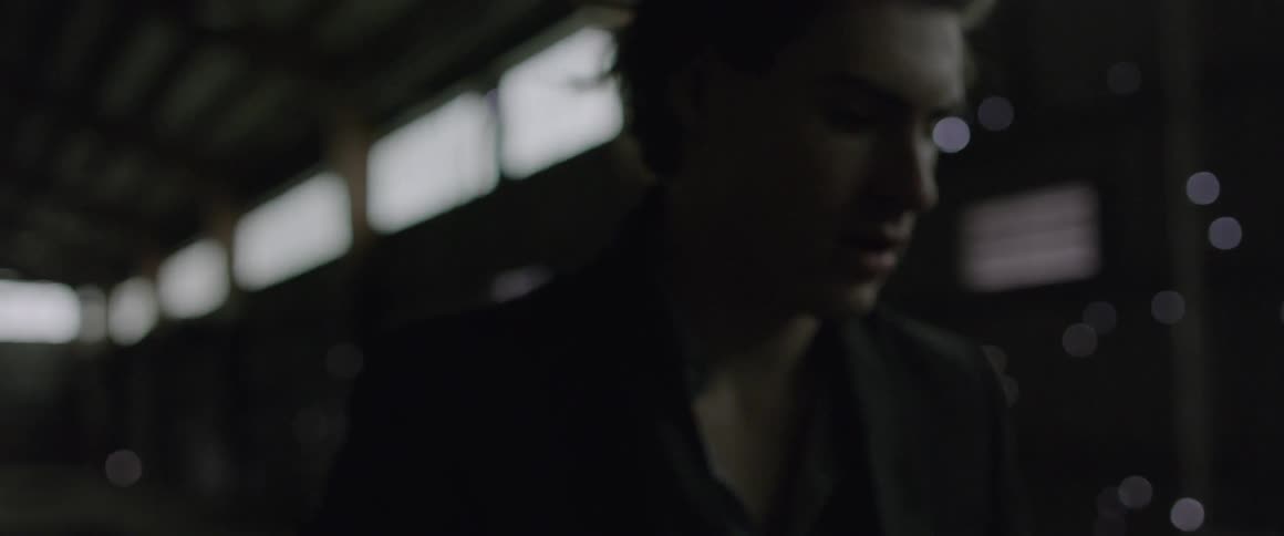 Man is standing in a dark warehouse