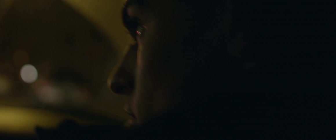 A man rides in a car at night