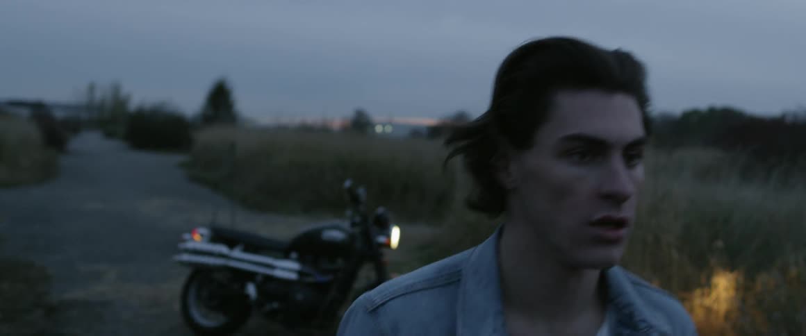 A man walks away from a parked motorcycle