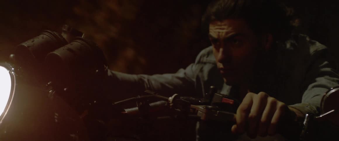 A man rides on a motorcycle at night