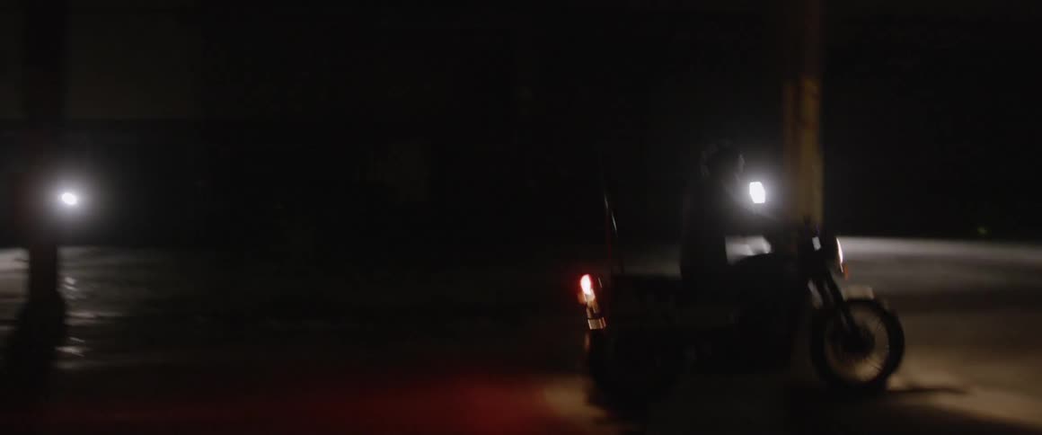 A motorcyclist rides at night