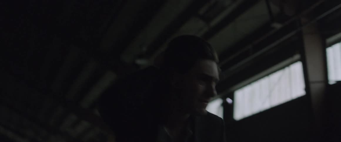 A man paces in a warehouse