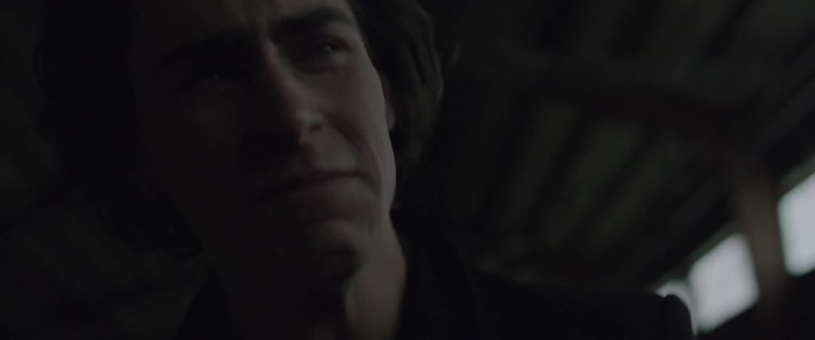 A man standing inside an abandoned building in daylight is shaking and crying