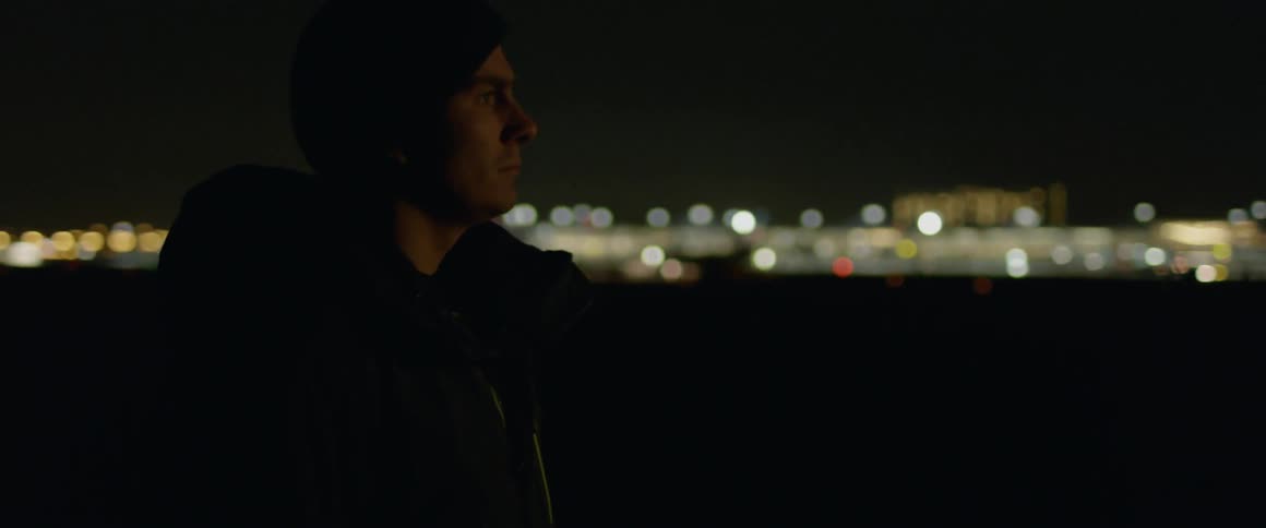 Man standing outside near an airport at night