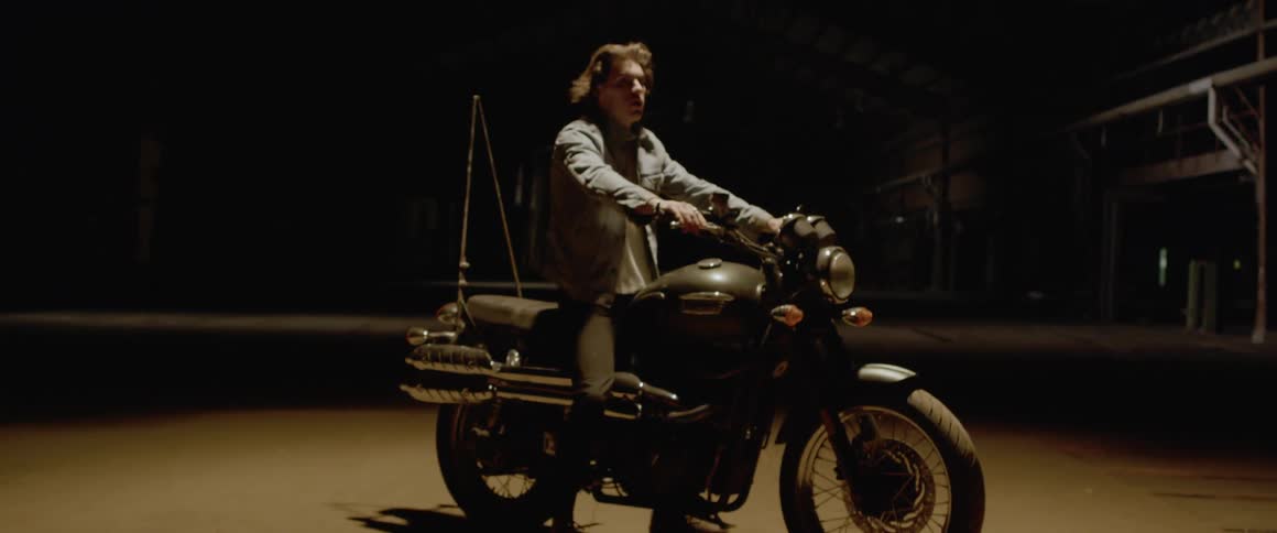 A man sits on a motorcycle