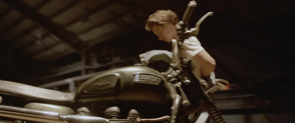 A man uncovers a motorcycle