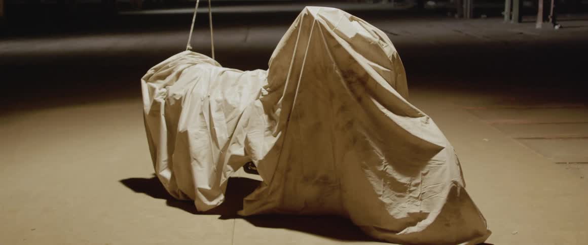 Beige drop cloth covers a large object