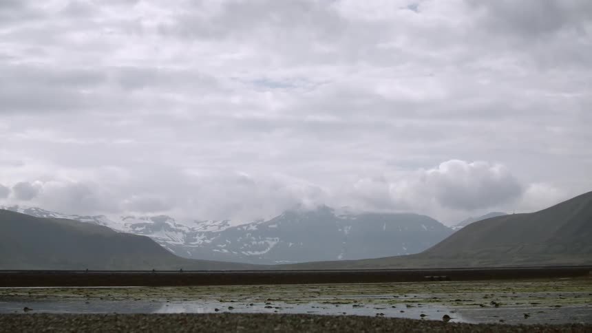 Clouds float over snow capped mountains