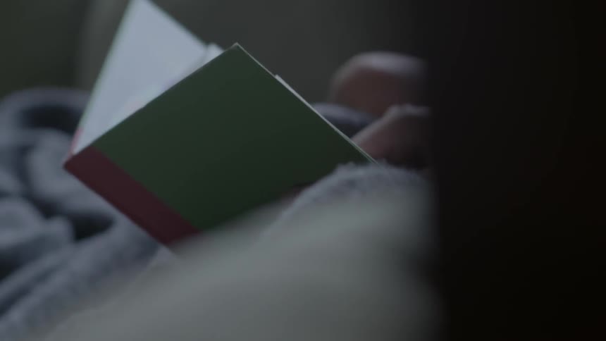 Someone holding a book as children snuggle up to them