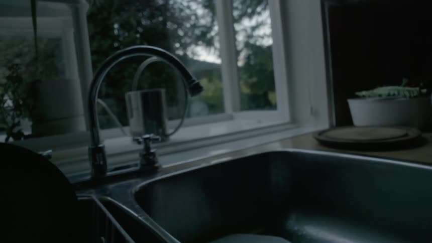 Dishes sit in a kitchen sink