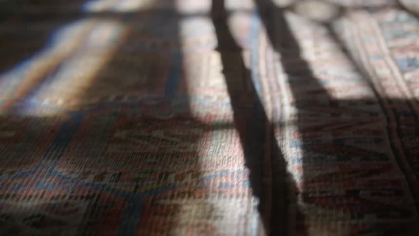 Sunlight casting patches of light and shadows on a rug