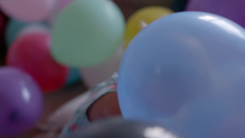 A child happily plays with balloons
