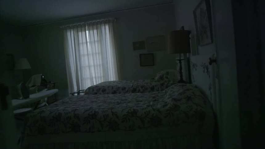 A bedroom with two beds and an ironing board