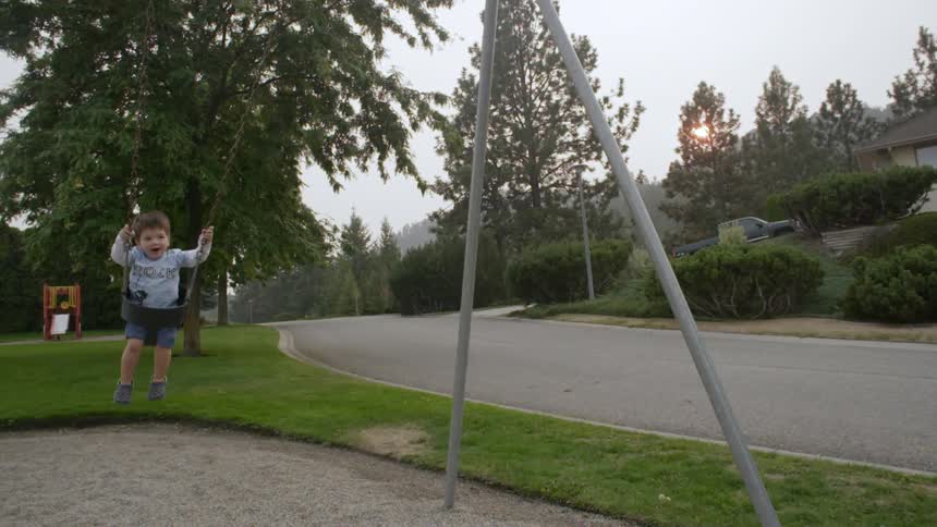 A toddler swings at a park