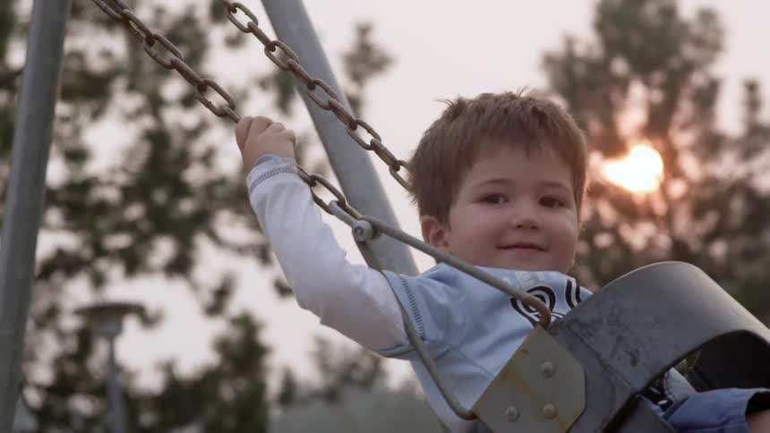 A toddler swings in the evening