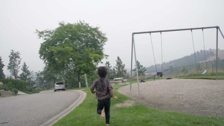 Child running barefoot through a park