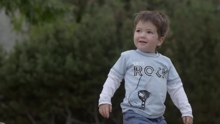 Toddler walking outside by trees