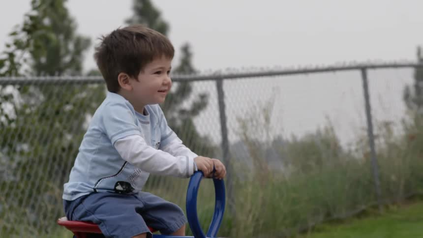 Small boy smiling while riding on a teeter totter