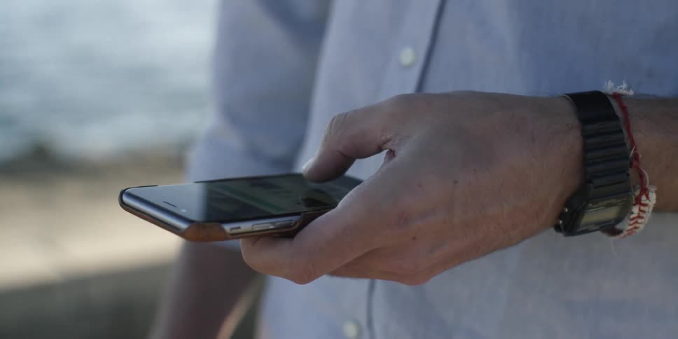 A man scrolls on a smartphone