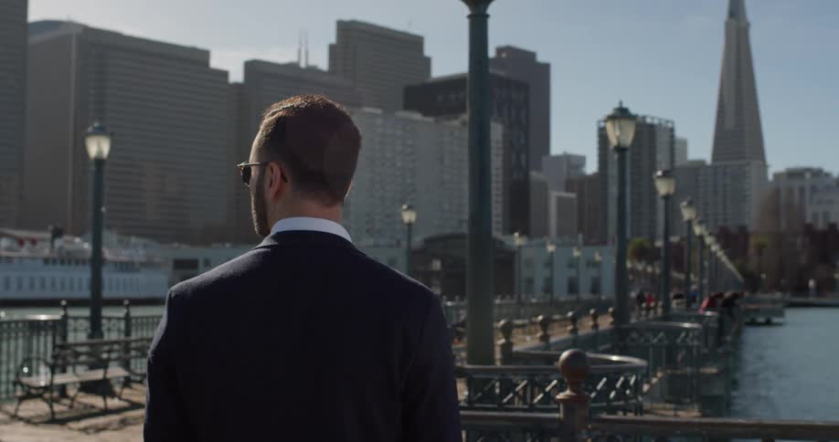 A man stands on a city pier