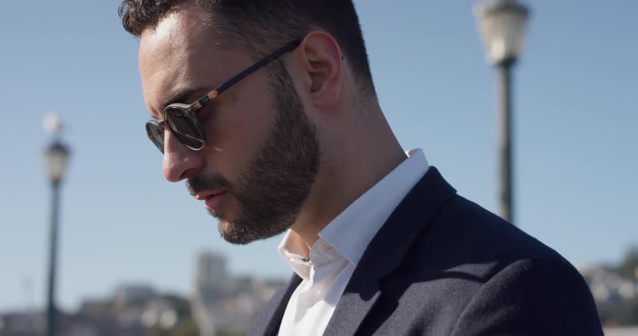 A man in a suit stands outside