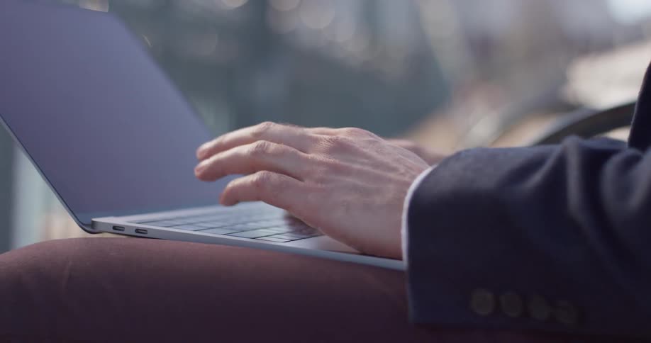 A man uses his laptop outside