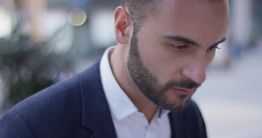 Bearded man blinks as he looks down