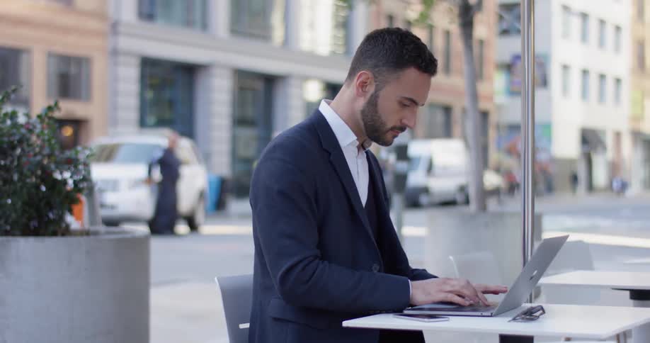 A man uses his laptop outside