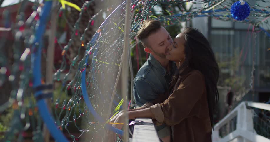 A man and woman kiss outside