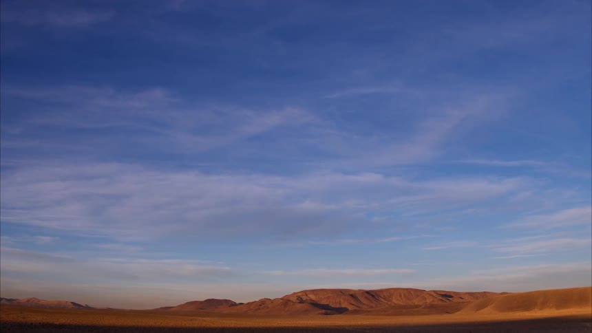 Wispy clouds over hilly desert