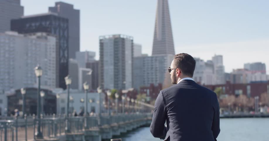 A man stands on a city pier