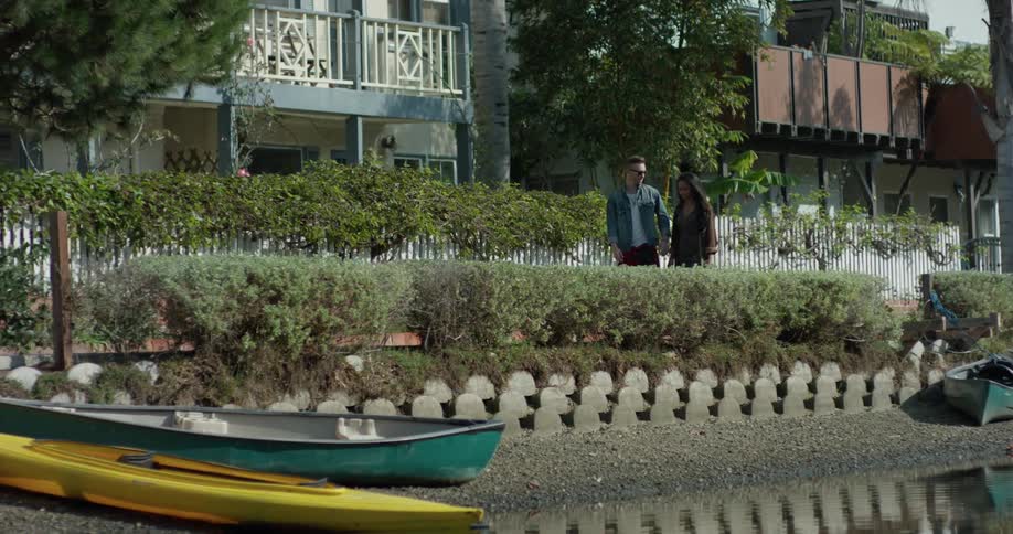 A man and woman hold hands as they walk