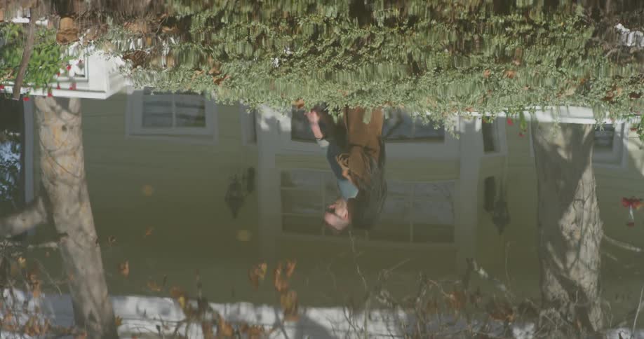 A man and woman are reflected in the water as they walk