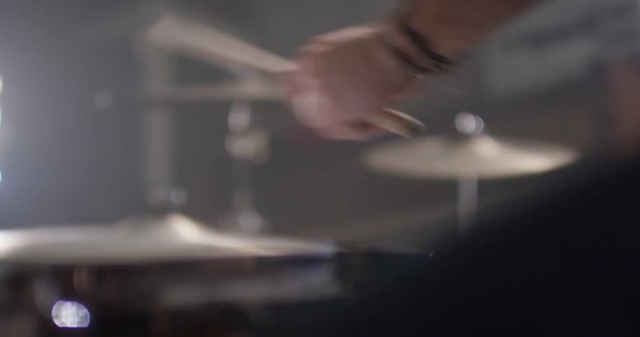 A man plays drums with drumsticks