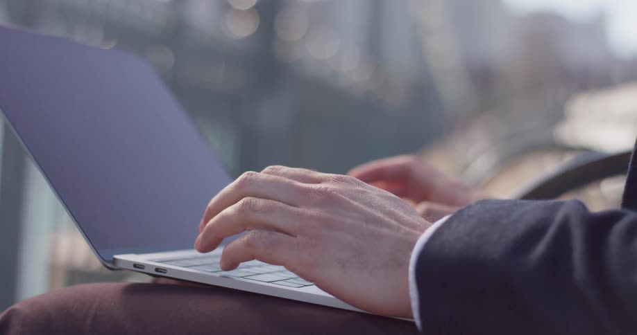 Man types on a laptop