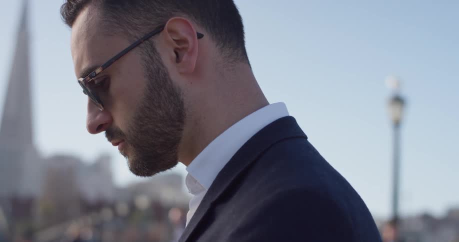 A man in a suit stands outside