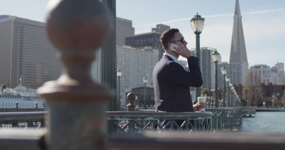 A man in a suit uses his phone outside